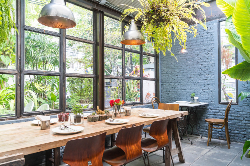 Indoor view of a restaurant with many plants for decoration constructed by M8 Fitout