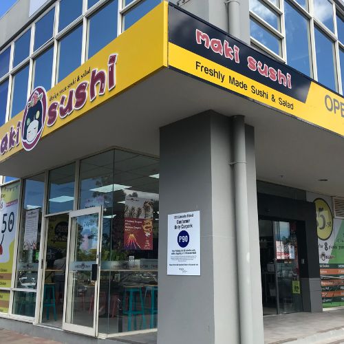 Exterior of Maki Sushi restaurant with large windows and signage.