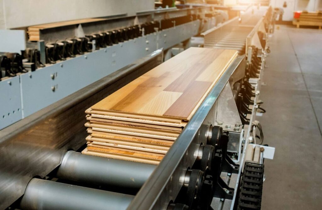 Wooden planks on a conveyor belt in a carpentry workshop.