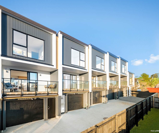 Row of modern townhouses with large windows and balconies.