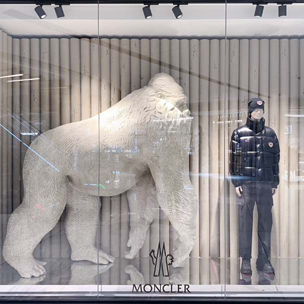 Store display with a gorilla statue and mannequin in Moncler clothing.