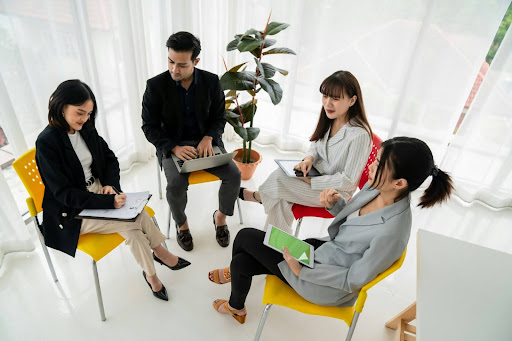 Four people having a meeting in a bright office space.