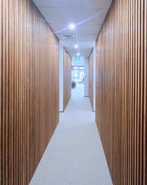 Wood-paneled hallway leading to a bright office space.