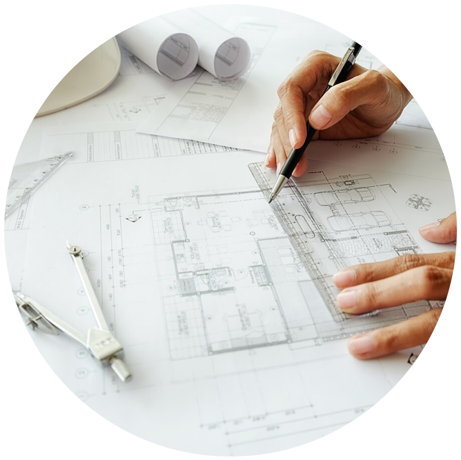 Person drawing architectural plans with compass and blueprints.